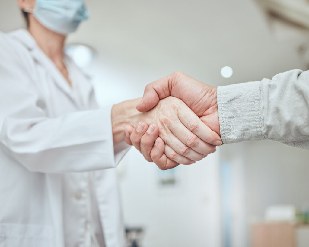 Close-up of hands shaking, symbolizing trust and partnership in holistic dental care