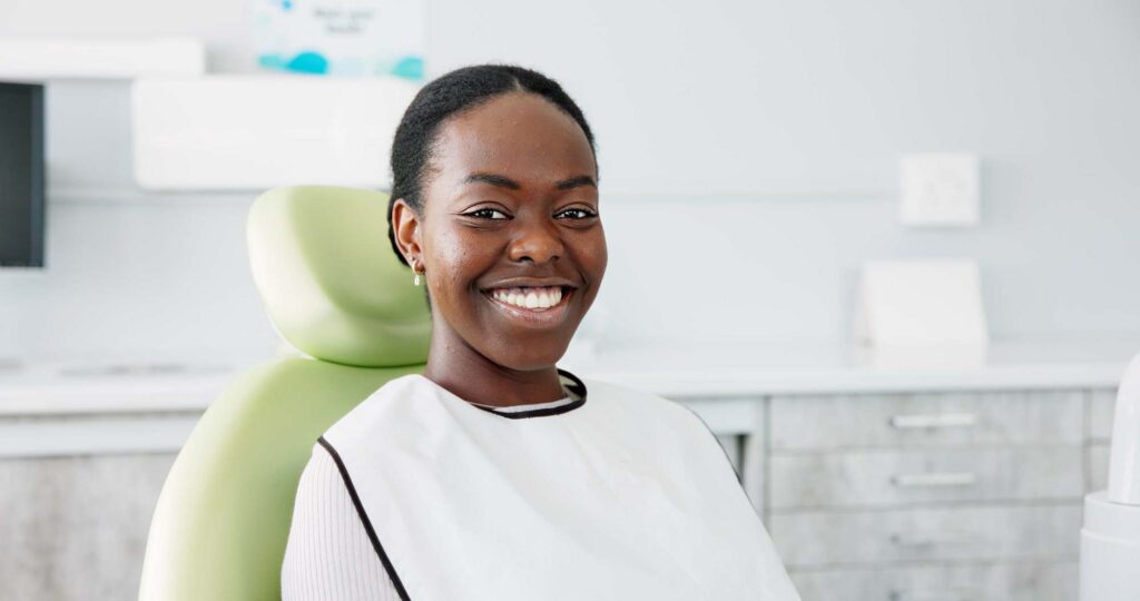 Smiling Black woman receiving dental care from Dr. Cody Dunnington, a family dentist offering metal-free treatment