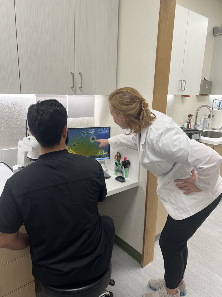 Dr. Dunnington and assistant reviewing microscope slides at Apollonia Dental as part of holistic dental diagnostics