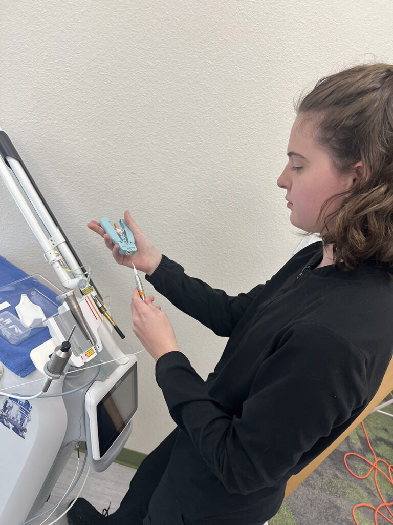 Dental assistant using the Fotona laser at Apollonia Dental for advanced, metal-free treatment